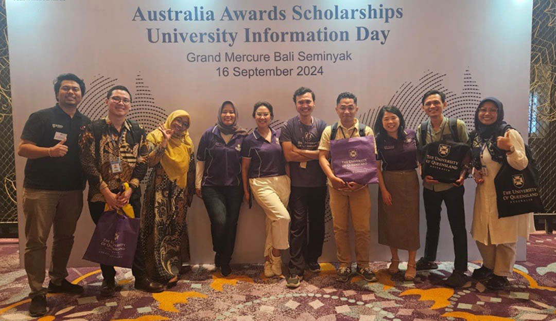 A group of Australia Awards scholars and alumni stand with Miho Hamada under the banner for the Australia Awards Scholarships University Information Day, 16 September 2024. 