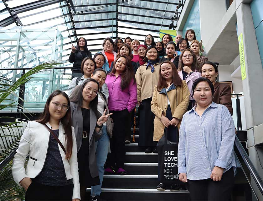 Dr  Ambaselmaa Bayarsaikhan with her cohort from the Australia Awards Short Course Women in STEM Mongolia. They are standing on a set of stairs with the photograph looking up toward the group of women. 