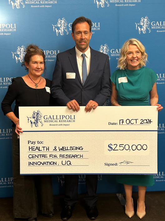 Dr Nicholas Gilson with two colleagues holding $250K cheque