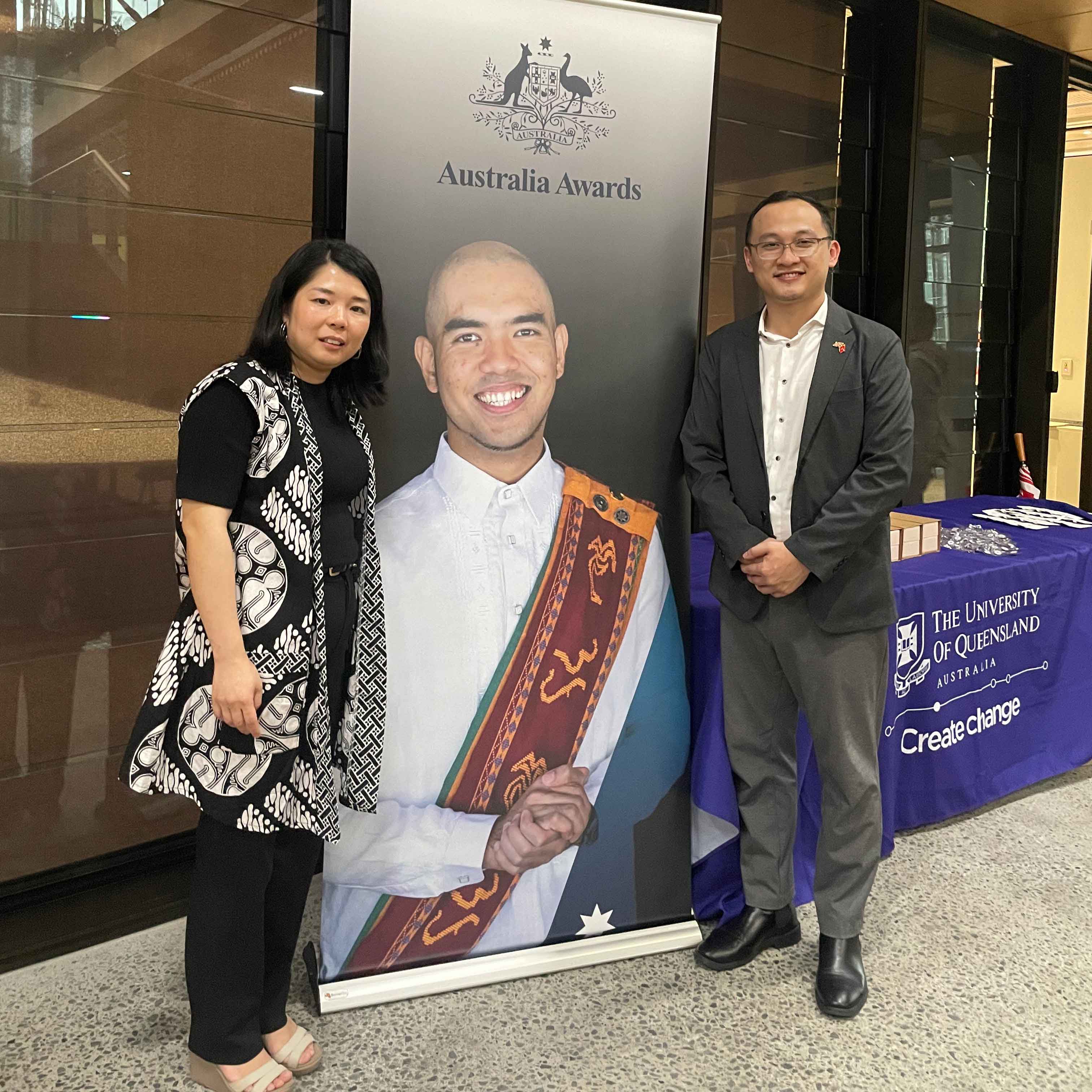 Miho Hamada stands with Khang Nguyen with an Australia Awards banner between them