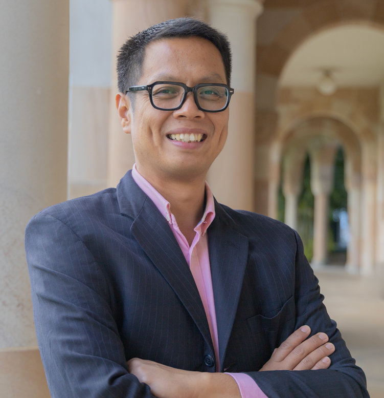 Dr Jaime Manalo IV stands in the Great Court of St Lucia in front of sandstone pillars