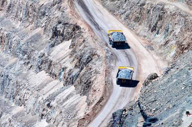 Two trucks carrying mineral rocks in a mining pit