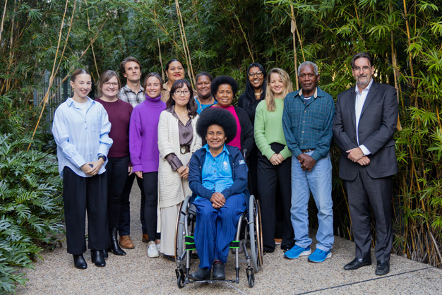 Group photo of IOC committee members at UQ smiling to camera
