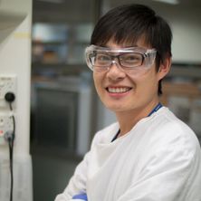 Dr Cheng in lab glasses over his own prescription glasses in a lab coat