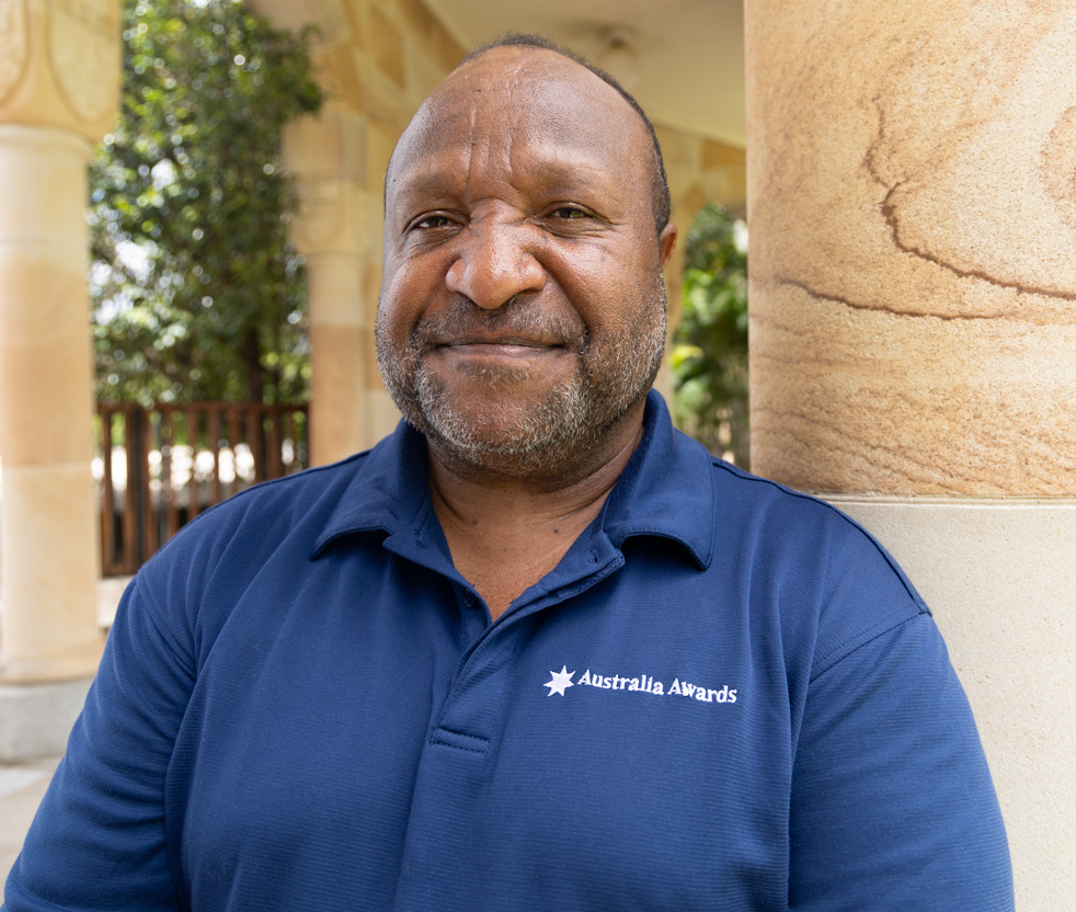 Cedric in UQ Great Court wearing Australia Awards t-shirt