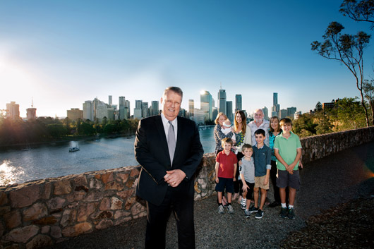 Professor Matt Sanders in front of Brisbane skyline and a family