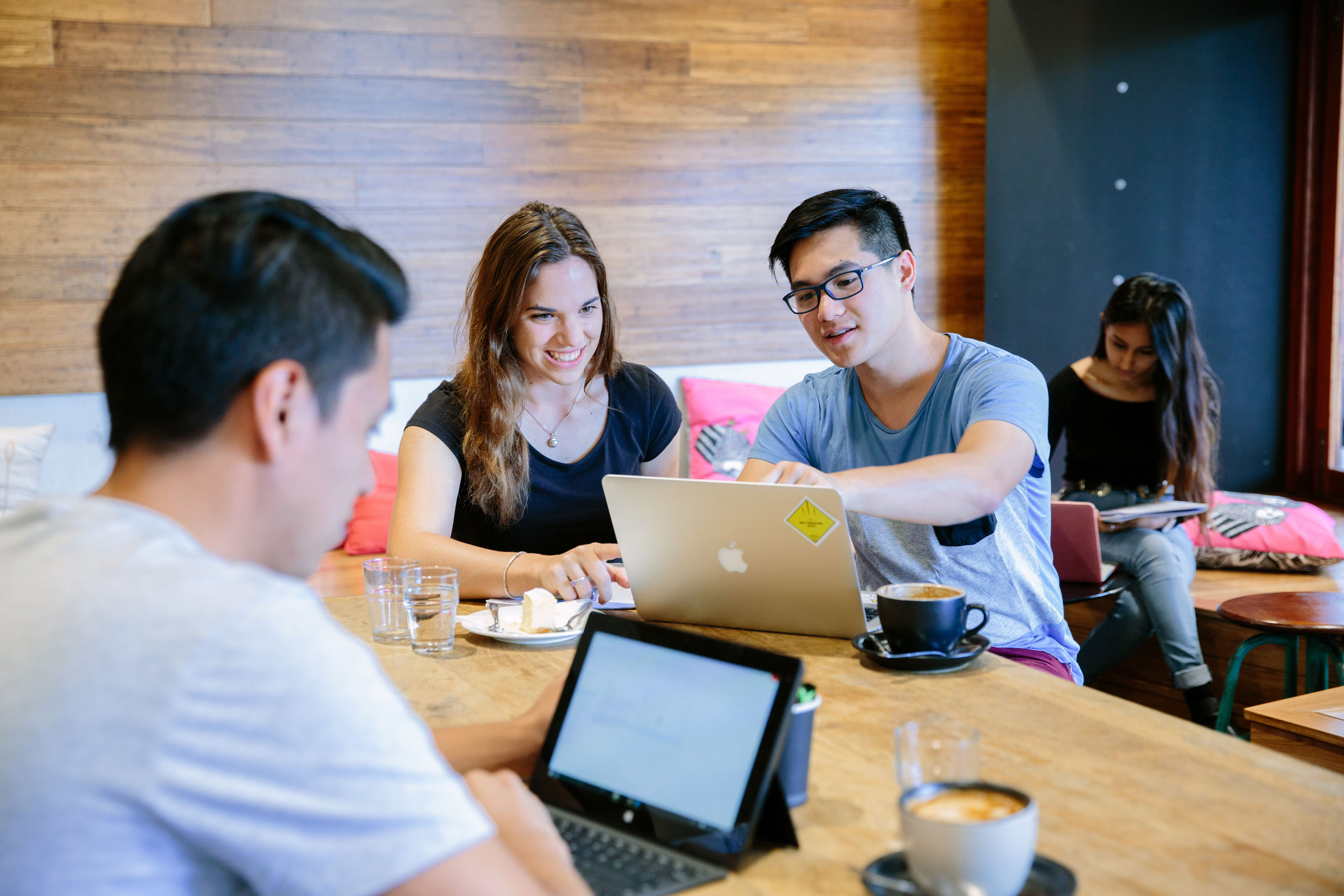 People sat at a table with their laptops working together