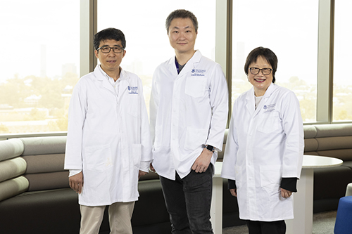 UQ researchers in white coats with UQ logo