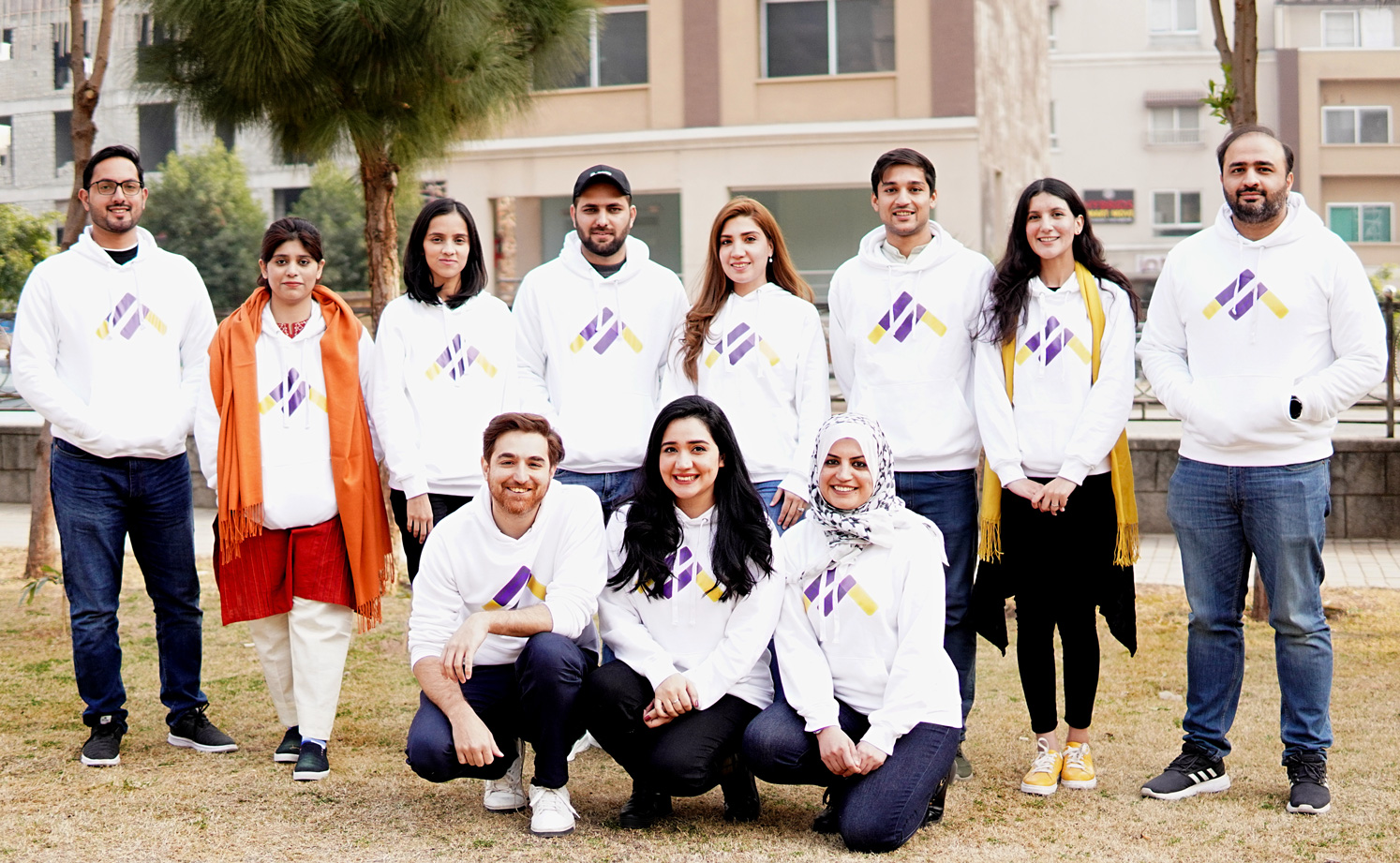 Metric founders wearing their the same white jumper with finance logo - upturned triangle with equal sign built into the point 