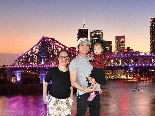 Miriam Agnes Yu and family standing in front of Brisbane skyline 