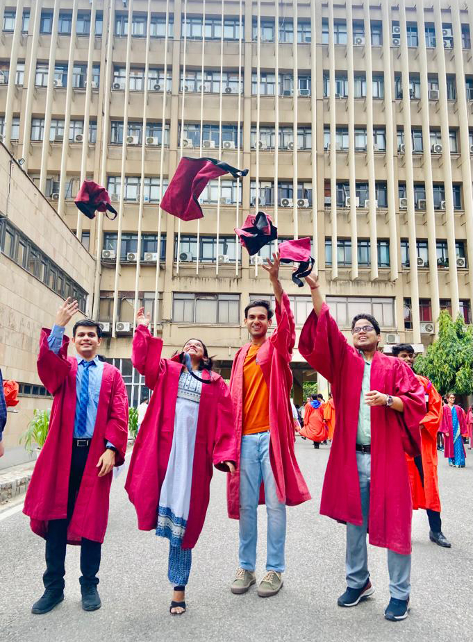 UQ-IITD PhD graduates throwing graduation capes into the air after graduating  