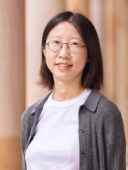 Lilly Zhao wearing glasses standing against Great Court sandstone pillars
