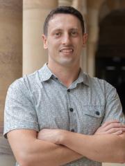 Matt in UQ St Lucia in front of sandstone