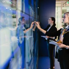 Two people standing and writing on an interactive wall