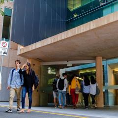 students walking in and out of ICTE building. Sign reads 'shared zone'