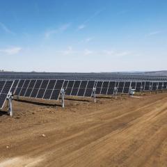 blue sky and rows of solar panels lined up on the ground