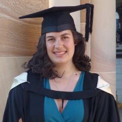 UQ graduate standing by great Court sandstone 