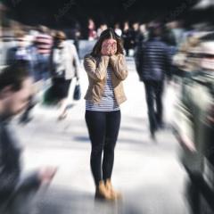 Woman in a crowd - in focus - with everyone around her blurred