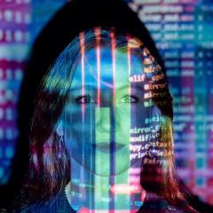 caucasian woman with computer language running over her face in multiple colours