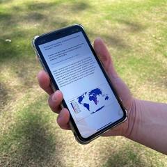 Mobile phone with app showing world map