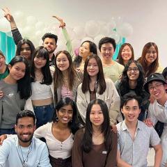 Group of students posing in front of balloons