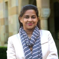 Tahmina Haque in the Great Court with sandstone pillars behind her