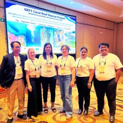 Prabowo, Jacquelyn Beattie, Neelam Bhan, Joelle Albert, Joslin Chetty, Derta Prabuning in front of Coral Reef Rescue Project display