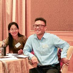 Thant laughing leaning on table during Australia Awards Myanmar course