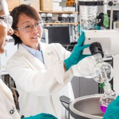Two scientists (women) in lab coats overseeing research