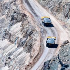 Two trucks carrying minerals in a mining pit