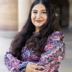 Prachi Rehan in the Great Court standing with the sandstone columns behind her