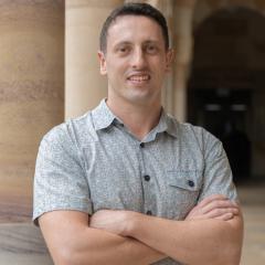 Matt in UQ St Lucia in front of sandstone