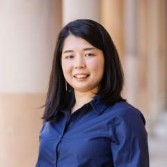 Miho smiling and standing in front of sandstone columns in UQ's Great Court