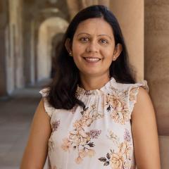 Nitika leaning against sandstone in UQ Great Court