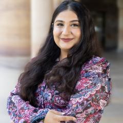 Prachi Rehan in the Great Court standing with the sandstone columns behind her
