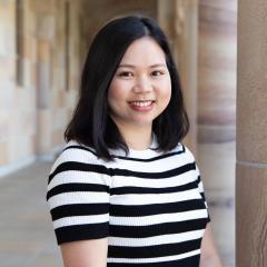 Thoa Harring smiling to camera in the sandstone columned Great Court of UQ