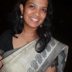 Ms Babu in a sari smiling to camera