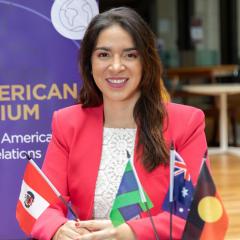 Martha holds Peru flag, with Australia, Torres Strait Islander and Australian flags in front of her. 