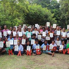 Group of PNG conservation scientists in the field smiling to camera