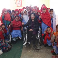Abia Akram giving peace sign surrounded by other girls with physical disabilities
