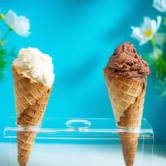 two icecreams in front of bright blue wall
