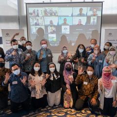 Participants wearing masks in front of onscreen fellow participants - like a virutal and in-person group shot