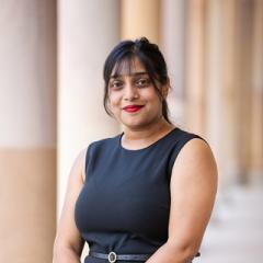 Krishtee formal headshot in sleeveless dress in front of sandstone columns at UQ St Lucia 'Great Court'