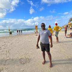 Nelson on an Aussie beach with two lifesavers behind him