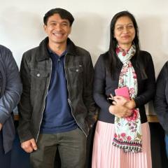 All four members of the Society smiling with the blue triangle with one star branding of Australia Awards