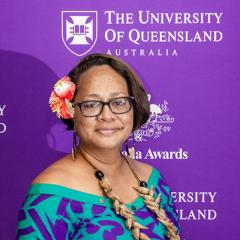 Sophia in front of media wall with University of Queensland and Australia Awards in bold letters