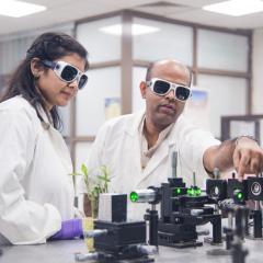 people in lab with goggles looking at research implements 
