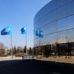 TUM flags next to, and reflecting in building